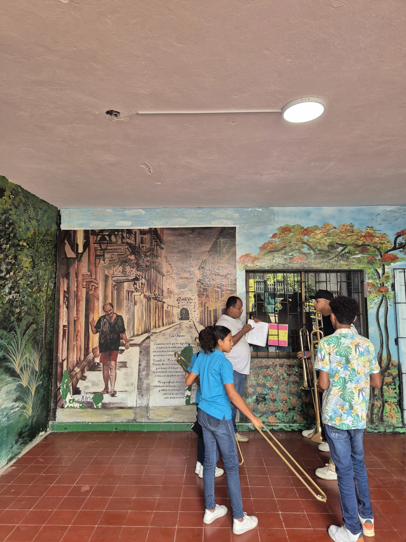 Adonay Torregrosa da instrucciones a Cristian Ospino y los demás trombones en la entrada de uno de los edificios del colegio INEM del barrio El Bosque. 